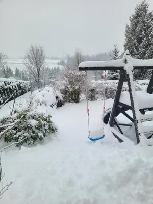 a swing in a yard covered in snow at Apartamencik Pod Krokusem 2 in Rabka