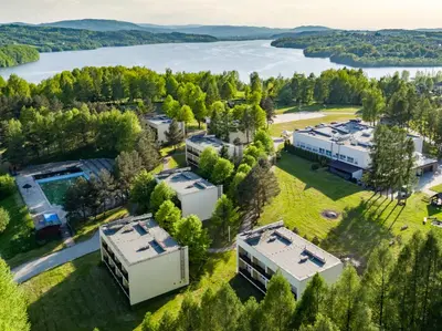 an aerial view of a building with a lake in the background at Hotel Dobczyce in Dobczyce