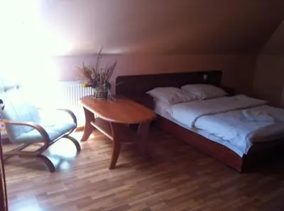 a bedroom with a bed and a table and a chair at Zajazd Pasja in Sławków