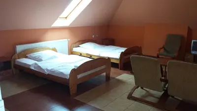 a room with two beds and a table and chairs at Zajazd Pasja in Sławków