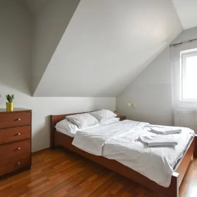 a bedroom with a bed with white sheets and a dresser at Zajazd Pasja in Sławków
