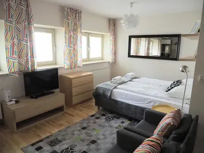 a bedroom with a bed and a tv and a couch at Yourplace Central Apartments in Kraków
