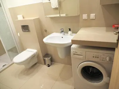 a bathroom with a washing machine and a sink at Yourplace Central Apartments in Kraków