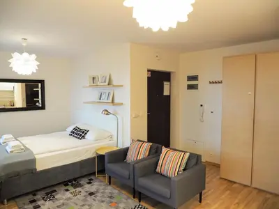 a bedroom with a bed and a couch and a chair at Yourplace Central Apartments in Kraków