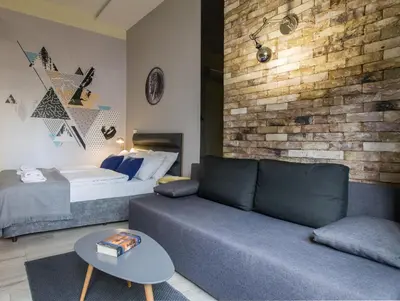 a living room with a couch and a bed at Yourplace Central Apartments in Kraków