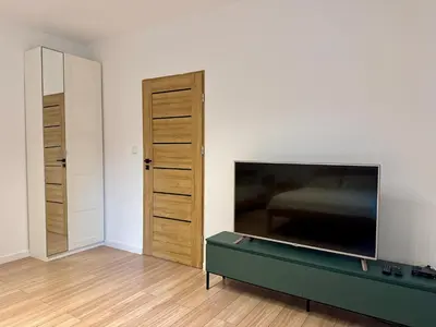 a living room with a flat screen tv and a closet at Zinc FAM in Oświęcim