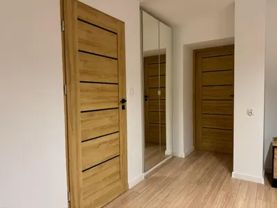 a room with two wooden doors and a mirror at Zinc FAM in Oświęcim