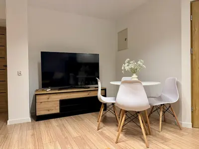 a living room with a table and a tv at Zinc FAM in Oświęcim