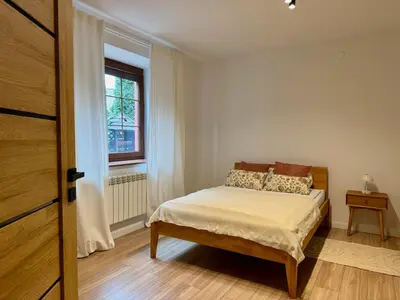 a small bedroom with a bed and a window at Zinc FAM in Oświęcim