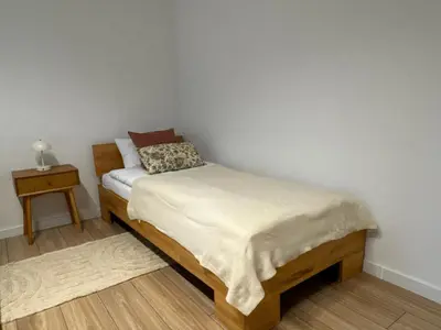 a small bedroom with a bed and a night stand at Zinc FAM in Oświęcim