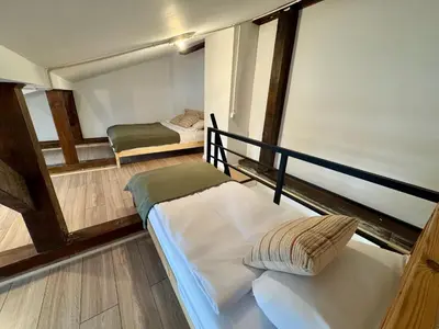 a couch sitting in a living room next to a staircase at Cozy Cottage in Oświęcim