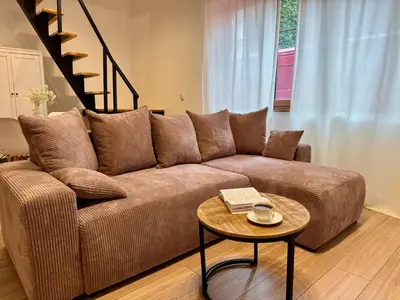 a living room with a brown couch and a table at Cozy Cottage in Oświęcim