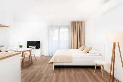 a white bedroom with a bed and a desk at City of the Kings-Riverside WT2 in Kraków