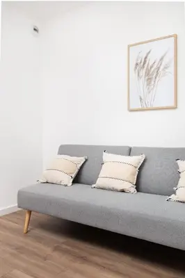 a gray couch with pillows in a living room at City of the Kings-Riverside WT2 in Kraków