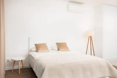 a white bedroom with a bed and a table at City of the Kings-Riverside WT2 in Kraków