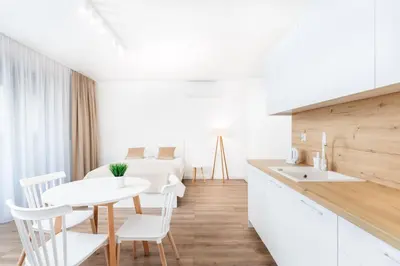 a kitchen and dining room with a white table and chairs at City of the Kings-Riverside WT2 in Kraków