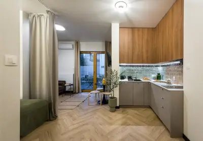 a kitchen and living room with wooden cabinets at WLB Apartments Comfort in Kraków