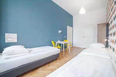 two beds in a room with a blue wall at Atlantis Hostel in Kraków