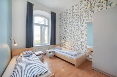 a bedroom with two beds and a window at Atlantis Hostel in Kraków
