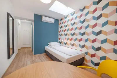 a room with a bed and a geometric wall at Atlantis Hostel in Kraków