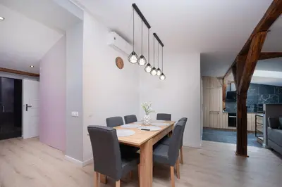 a dining room with a wooden table and chairs at Apartament Solny Loretańska in Kraków