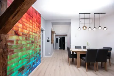 a dining room with a large colorful painting on the wall at Apartament Solny Loretańska in Kraków