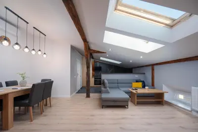 a dining room with a table and chairs and skylights at Apartament Solny Loretańska in Kraków