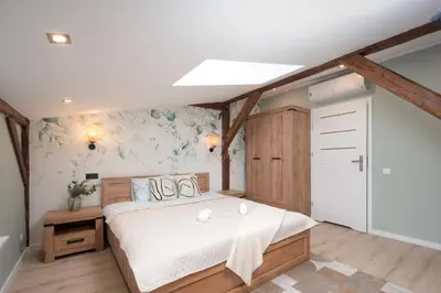 a bedroom with a large bed with white sheets at Apartament Solny Loretańska in Kraków