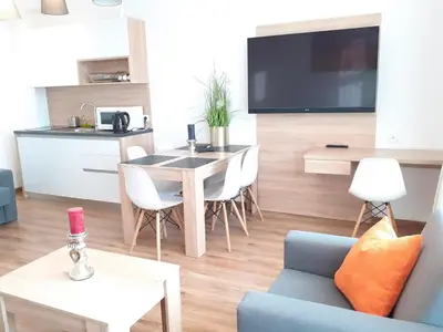 a kitchen and living room with a table and chairs at Old Town Apartments - Bosacka B18 in Kraków