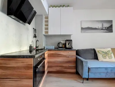 a kitchen with a stove top oven next to a couch at Królowej Jadwigi 9 by Homeprime in Kraków