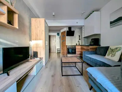 a living room with a blue couch and a tv at Królowej Jadwigi 9 by Homeprime in Kraków