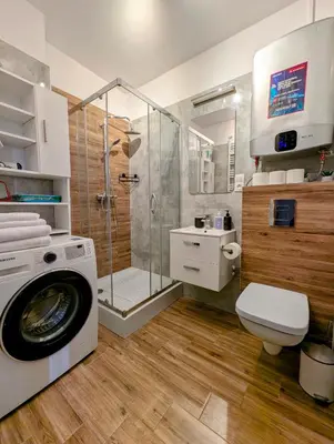 a bathroom with a shower and a washing machine at Królowej Jadwigi 9 by Homeprime in Kraków