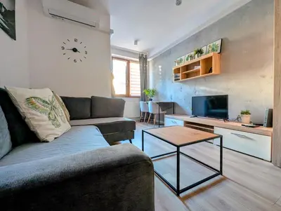 a living room with a couch and a clock on the wall at Królowej Jadwigi 9 by Homeprime in Kraków