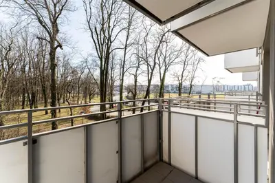 a balcony of a building with trees in the background at Malila Premium Apartments Cracow Konopnickiej 63E in Kraków