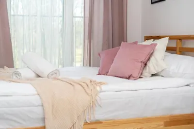 a bed with pink and white pillows on it at Malila Premium Apartments Cracow Konopnickiej 63E in Kraków