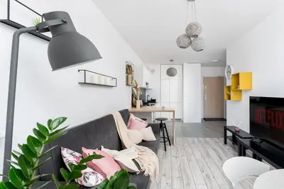 a living room with a black couch with pillows at Malila Premium Apartments Cracow Konopnickiej 63E in Kraków