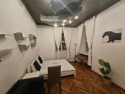 a room with a bed and a table and a window at Enios Apartments ul Św Tomasza 33 in Kraków