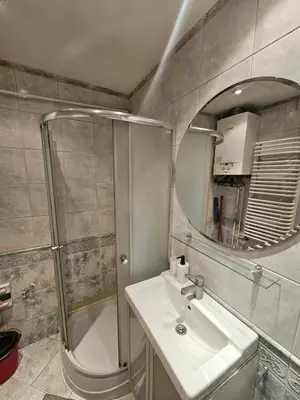 a bathroom with a shower and a sink and a mirror at Enios Apartments ul Św Tomasza 33 in Kraków