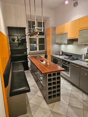a kitchen with a wooden table and benches in it at Enios Apartments ul Św Tomasza 33 in Kraków