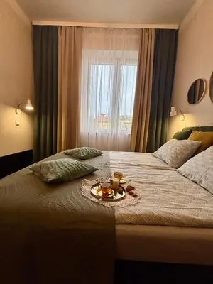 a bedroom with a bed with a tray of food on it at Vintage Krowoderska Apartment in Kraków