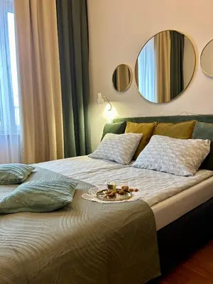 a large bed with a plate of food on it at Vintage Krowoderska Apartment in Kraków