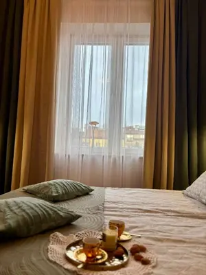 a bed with a plate of food and a window at Vintage Krowoderska Apartment in Kraków