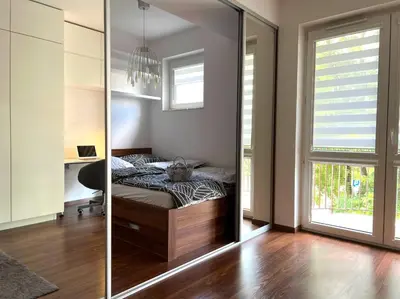 a bedroom with a bed and a desk and a mirror at Aspen Studio in Kraków