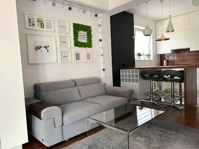 a living room with a couch and a kitchen at Aspen Studio in Kraków