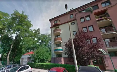a tall building with cars parked in front of it at Aspen Studio in Kraków