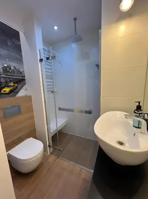 a bathroom with a toilet and a sink and a shower at Aspen Studio in Kraków