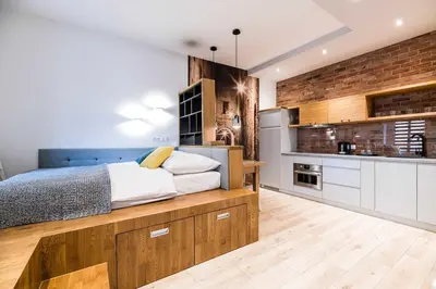 a bedroom with a large bed and a brick wall at Saguaro Deluxe Apartment Old Town Cracow in Kraków