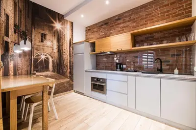 a kitchen with a table and a brick wall at Saguaro Deluxe Apartment Old Town Cracow in Kraków