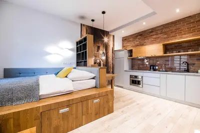 a bedroom with a large bed and a kitchen at Saguaro Deluxe Apartment Old Town Cracow in Kraków