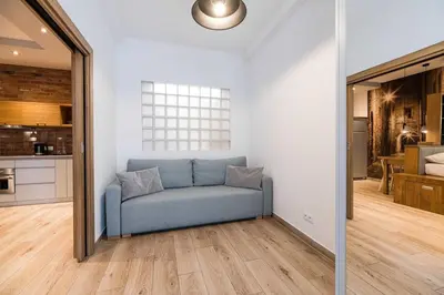 a blue couch in a room with a kitchen at Saguaro Deluxe Apartment Old Town Cracow in Kraków